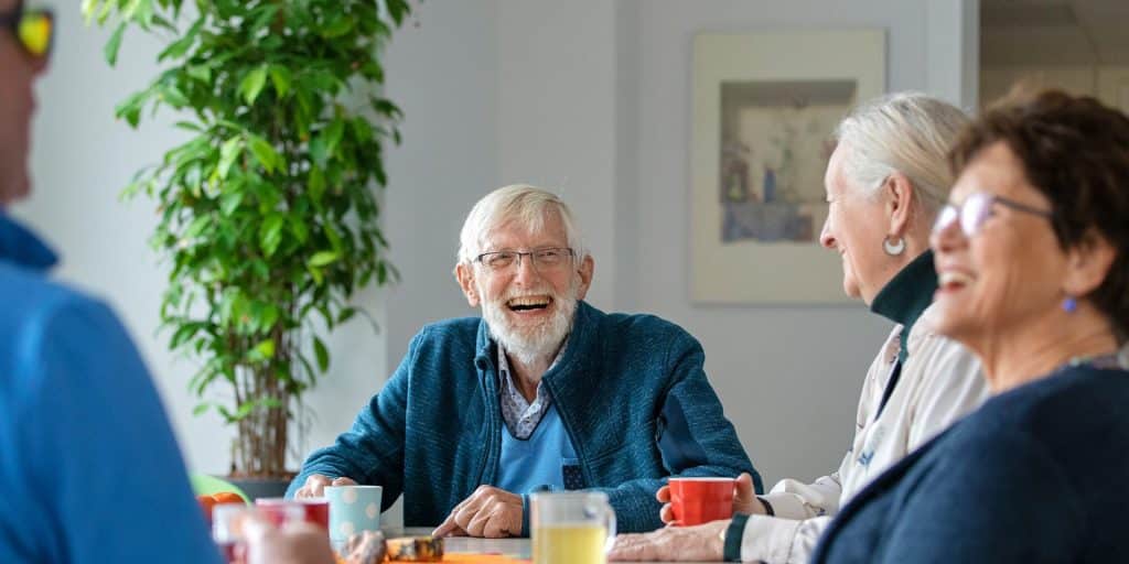 ouderen lachend aan de koffie